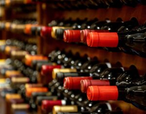 Pourquoi Investir Dans Le Vin Est-Il Une Bonne Stratégie Financière 6 bouteilles de vin alignees dans une cave