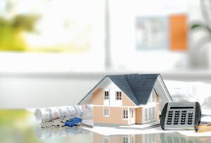 calculatrice et maison miniature sur table