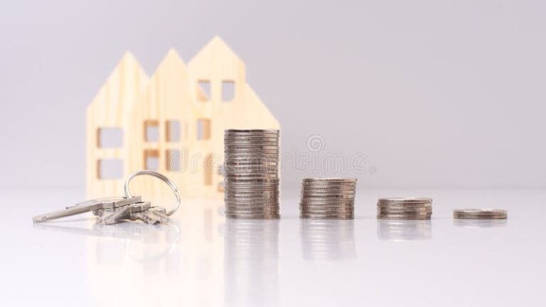 cle de maison avec pieces de monnaie empilees