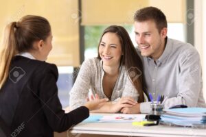 courtier immobilier discutant avec un couple heureux