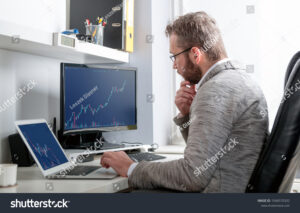 Comment investir en bourse avec Crédit Agricole : quelles options choisir 30 investisseur analysant graphiques boursiers sur ordinateur