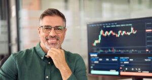 investisseur souriant avec graphiques financiers evolutifs