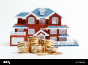 maison avec pieces de monnaie empilees devant