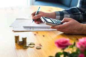 personne calculant son budget avec calculatrice