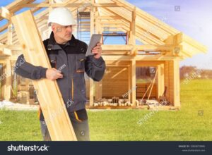 personne construisant une maison en bois
