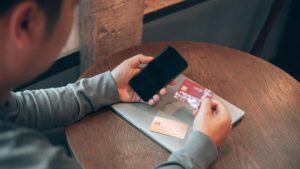 personne payant avec smartphone devant banque