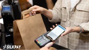 personne utilisant apple pay sur smartphone en magasin